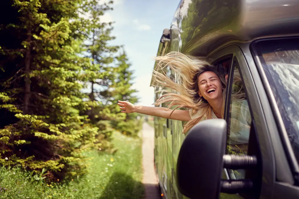 Woman leaning out of the passenger-side window of a RV